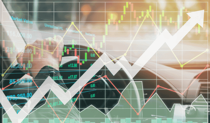 A person driving a car with a graph overlay, showcasing stock market fluctuations and an upward trend, reminds one of the comprehensive analysis often seen in Detroit car accident statistics.