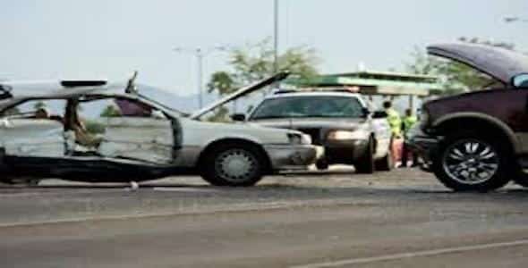 Two cars appear damaged in a collision on the road, with a police car and officers in the background. The surrounding area is clear. If you need guidance, our Personal Injury Lawyers can offer a free accident consultation to help navigate your next steps.