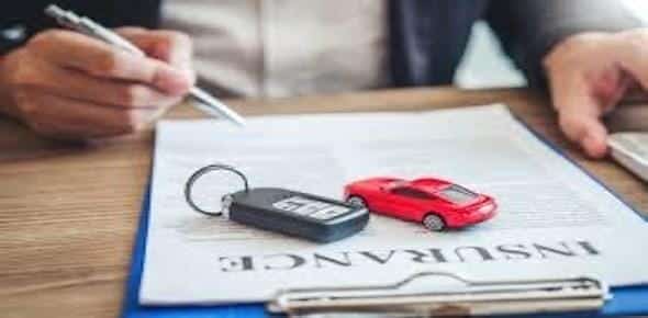 A person holds a pen over an insurance document, accompanied by a car key and a small red toy car. This scene reflects the typical process when dealing with Michigan's no-fault insurance regulations.