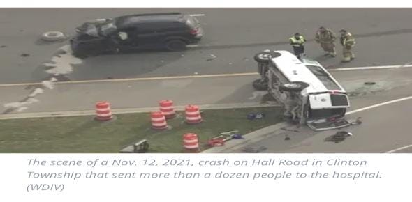 An aerial view of a car crash on Hall Road in Clinton Township reveals an overturned vehicle surrounded by orange cones. The scene, managed by vigilant firefighters, appears to be the aftermath of a severe T-bone crash.