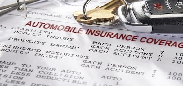 Automobile insurance documents with keys on top, explaining liability and coverage amounts for bodily injury and property damage. Includes steps to report a minor car accident efficiently.