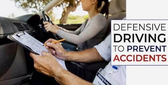 A person diligently takes notes beside a driver in a car, emphasizing "Defensive Driving to Prevent Collisions" as the ultimate approach to safety.
