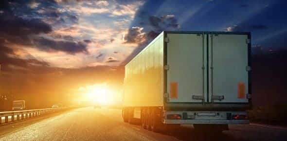 A truck glides along the highway at sunset, embodying the calm before transitioning to nighttime driving.